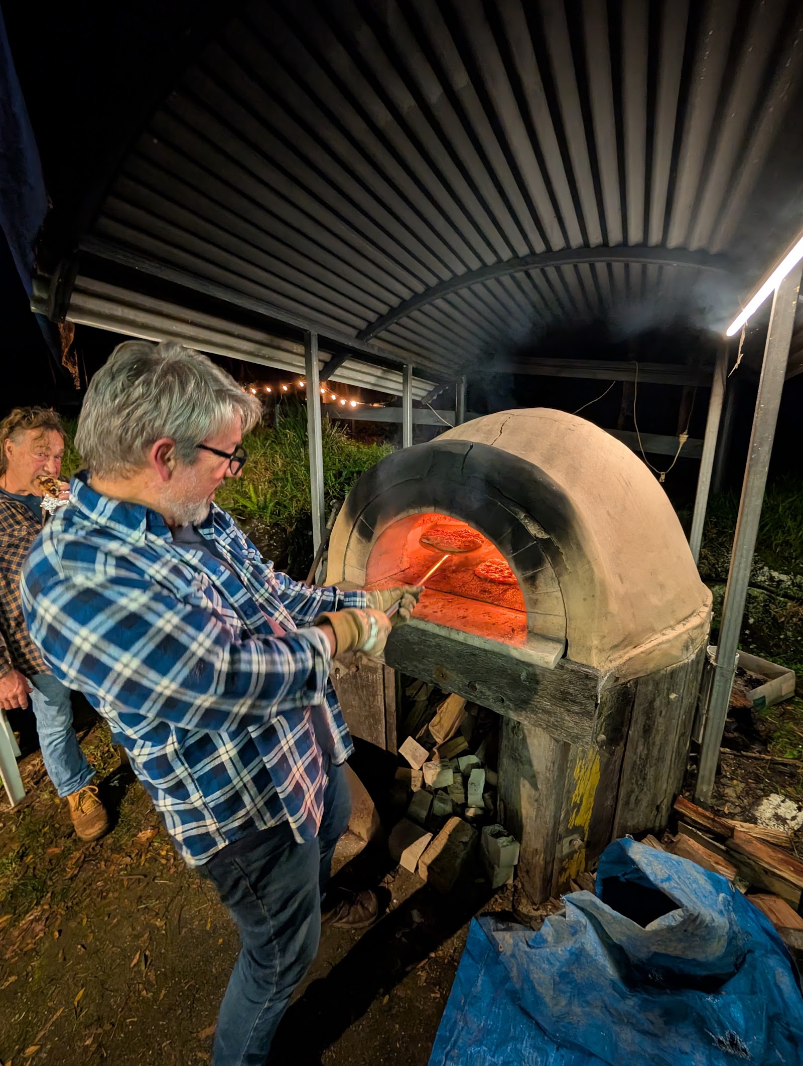 Volunteers cooking at a community BBQ with guests on the lawn