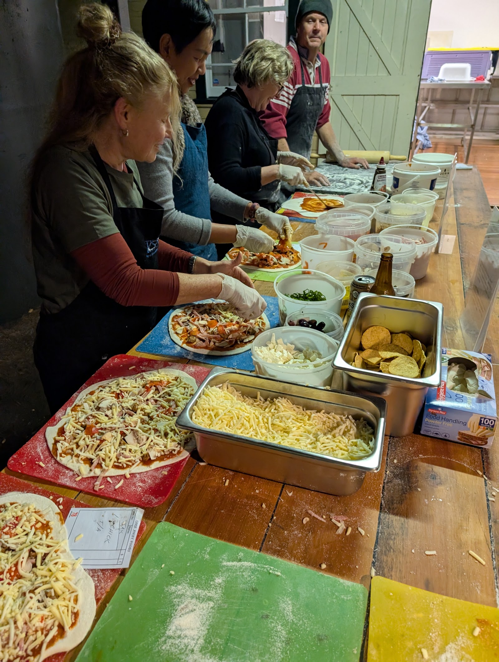 Community members preparing pizzas together