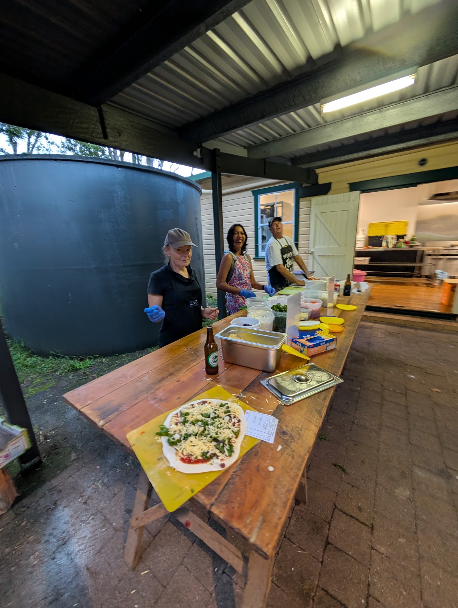 Volunteers laughing while preparing pizzas